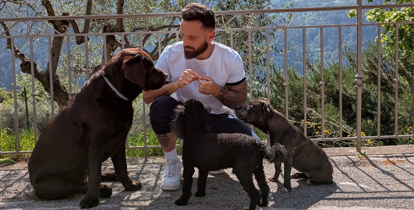 Anthony, éducateur canin, en séance avec trois chiens face aux collines des Alpes-Maritimes
